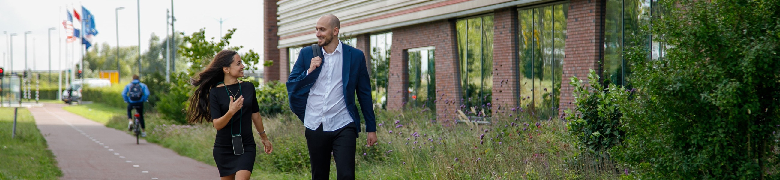2 colleagues talk while walking outside